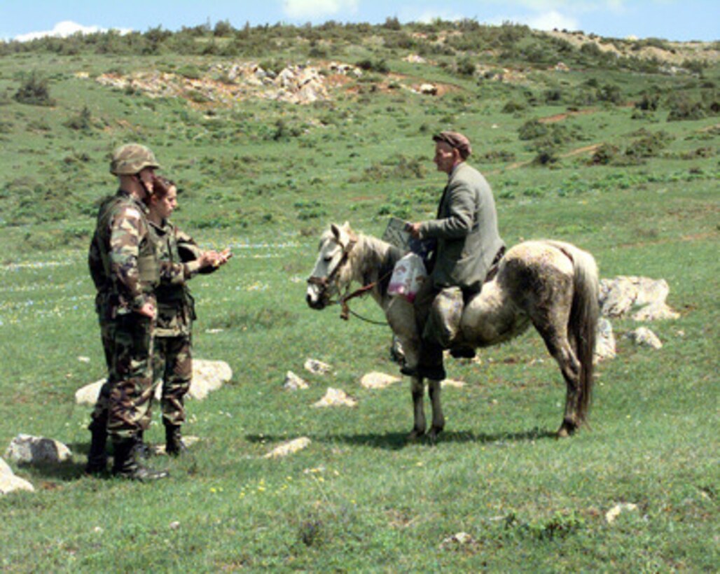 Staff Sgt. John J. McCarthy, U.S. Army, and his interpreter talk to a Kosovar Serb man after giving him a copy of "Dialog", a KFOR publication printed in Serbo-Croatian and Albanian, on May 4, 2000, in the Novo Brdo Obstina, Kosovo. McCarthy is attached to the 315th Psychological Operations Company, and is deployed to Camp Bondsteel, Kosovo, as part of KFOR. KFOR is the NATO-led, international military force in Kosovo on the peacekeeping mission known as Operation Joint Guardian. 