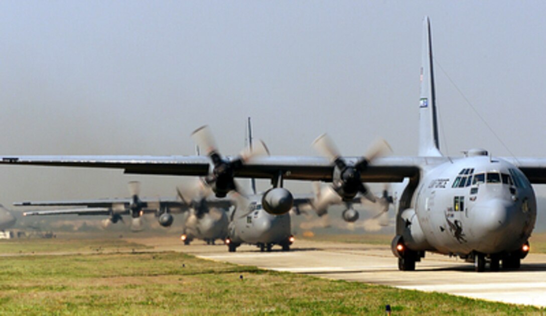 U.S. Air Force C-130 Hercules taxi down the runway at Pope Air Force Base, N.C., prior to loading up paratroopers for an airdrop during Air Mobility Rodeo 2000, on May 7, 2000. Rodeo 2000 is the U.S. Air Force Air Mobility Command's premier air mobility competition, involving more than 80 aircraft and 100 teams from 17 countries. The teams compete in airdrops, aerial refueling, aircraft navigation, special tactics, short field landings, cargo loading, engine running on and off load, aeromedical evacuations and security forces operations. The Hercules are attached to the 43rd Wing at Pope. 