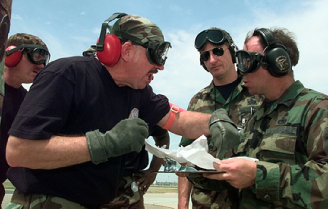 Competitors in the Engine Running On/Offload competition of Air Mobility Rodeo 2000 have to shout over the engine noise to discuss the event with the umpires on May 9, 2000. Rodeo 2000 is the U.S. Air Force Air Mobility Command's premier air mobility competition, involving more than 80 aircraft and 100 teams from 17 countries. The teams compete in airdrops, aerial refueling, aircraft navigation, special tactics, short field landings, cargo loading, engine running on and off load, aeromedical evacuations and security forces operations. 