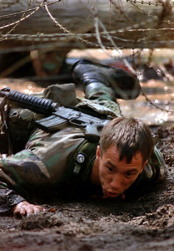 Senior Airman Mark Kling crawls under razor wire, one of the 23 obstacles on the Special Tactics Endurance Course, during Air Mobility Rodeo 2000 on May 10, 2000. Rodeo 2000 is the U.S. Air Force Air Mobility Command's premier air mobility competition, involving more than 80 aircraft and 100 teams from 17 countries. The teams compete in airdrops, aerial refueling, aircraft navigation, special tactics, short field landings, cargo loading, engine running on and off load, aeromedical evacuations and security forces operations. Kling is attached to the 22nd Special Tactics Squadron, McChord Air Force Base, Wash. 