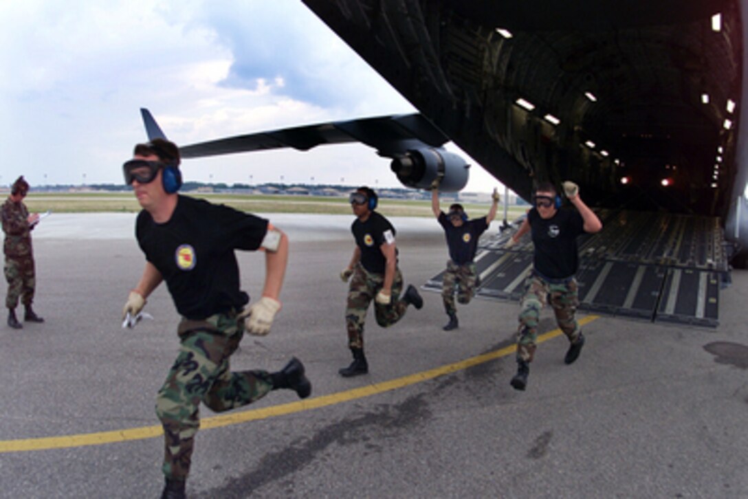 Staff Sgt. Wayne Donnely and Senior Airmen Kevin Taboada, Timothy Chew and David Owens run out of their C-17 Globemaster III during the Engines Running On/Offload competition of Air Mobility Rodeo 2000 on May 10, 2000. Rodeo 2000 is the U.S. Air Force Air Mobility Command's premier air mobility competition, involving more than 80 aircraft and 100 teams from 17 countries. The teams compete in airdrops, aerial refueling, aircraft navigation, special tactics, short field landings, cargo loading, engine running on and off load, aeromedical evacuations and security forces operations. Donnely, Taboada, Chew and Owens are air transportation specialists assigned to the 97th Air Mobility Wing, Altus Air Force Base, Okla. 