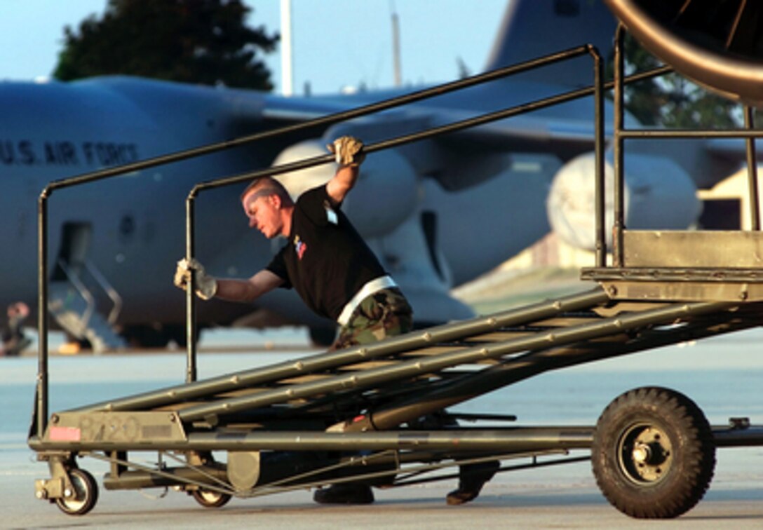 Tech. Sgt. Robert Jendrock rolls back a maintenance stand as he prepares to launch a C-141 Starlifter on May 10, 2000, at Pope Air Force Base, N.C., during Air Mobility Rodeo 2000. Rodeo 2000 is the U.S. Air Force Air Mobility Command's premier air mobility competition, involving more than 80 aircraft and 100 teams from 17 countries. The teams compete in airdrops, aerial refueling, aircraft navigation, special tactics, short field landings, cargo loading, engine running on and off load, aeromedical evacuations and security forces operations. Jendrock is an aircraft repair specialist with the 452nd Air Mobility Wing, March Air Reserve Base, Calif. 