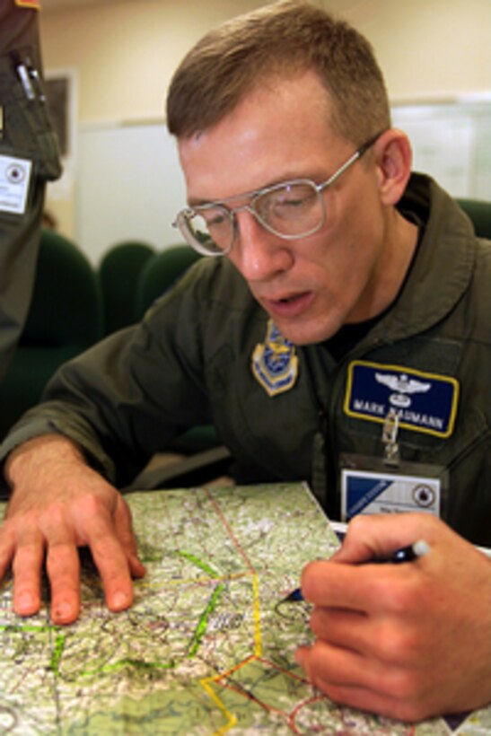 C-130 Hercules Navigator Maj. Mark Naumann prepares his mission brief prior to takeoff on a mission from Pope Air Force Base, N.C., for Air Mobility Rodeo 2000, on May 11, 2000. Rodeo 2000 is the U.S. Air Force Air Mobility Command's premier air mobility competition, involving more than 80 aircraft and 100 teams from 17 countries. The teams compete in airdrops, aerial refueling, aircraft navigation, special tactics, short field landings, cargo loading, engine running on and off load, aeromedical evacuations and security forces operations. Naumann is attached to the 327th Air Reserve Station, Willow Grove, Pa. 