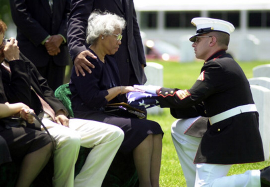 Gunnery Sgt. Roland Henderson presents Marion Boyd with the flag used to cover the casket of her son Marine Pfc. Walter Boyd during his ceremonial burial at Arlington National Cemetery on June 9, 2000. Boyd was killed on May 15, 1975, in a rescue attempt of the captured crew of the SS Mayaguez. The helicopter he was flying in came under heavy enemy fire as it approached the island where the crew was being held captive and crashed into the surf with 26 men on board. Half were rescued at sea, leaving 13 unaccounted for. Boyd was listed as Missing In Action until only recently. 