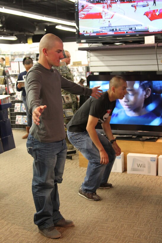 Marines play an Xbox 360 game with Kinect during the Single Marines Shopping Night Dec. 1, 2010, at the Marine Corps Exchange. The Kinect is a controller-free system that enables users to interact with the Xbox 360 using gestures, spoken commands or presented objects and images.
