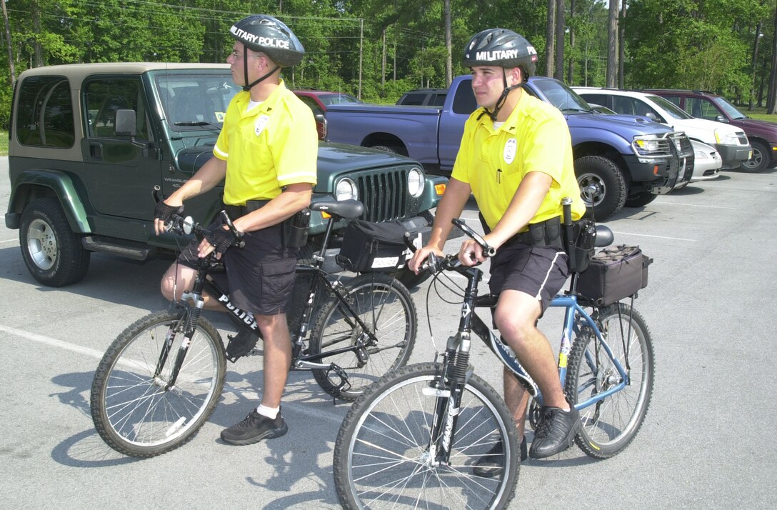 MARINE CORPS BASE CAMP LEJEUNE, N.C. - Cpl. Lon P. Roberson (left) and Cpl. Jason P. Lamke survey a parking lot while on duty here June 15. The Provost Marshal's Office has recently restarted its Bike Patrol unit, which began in May and will continue till the fall. Roberson and Lamke are military policeman with the PMO Bike Patrol. (Official U.S. Marine Corps photo by Lance Cpl. Brandon R. Holgersen)