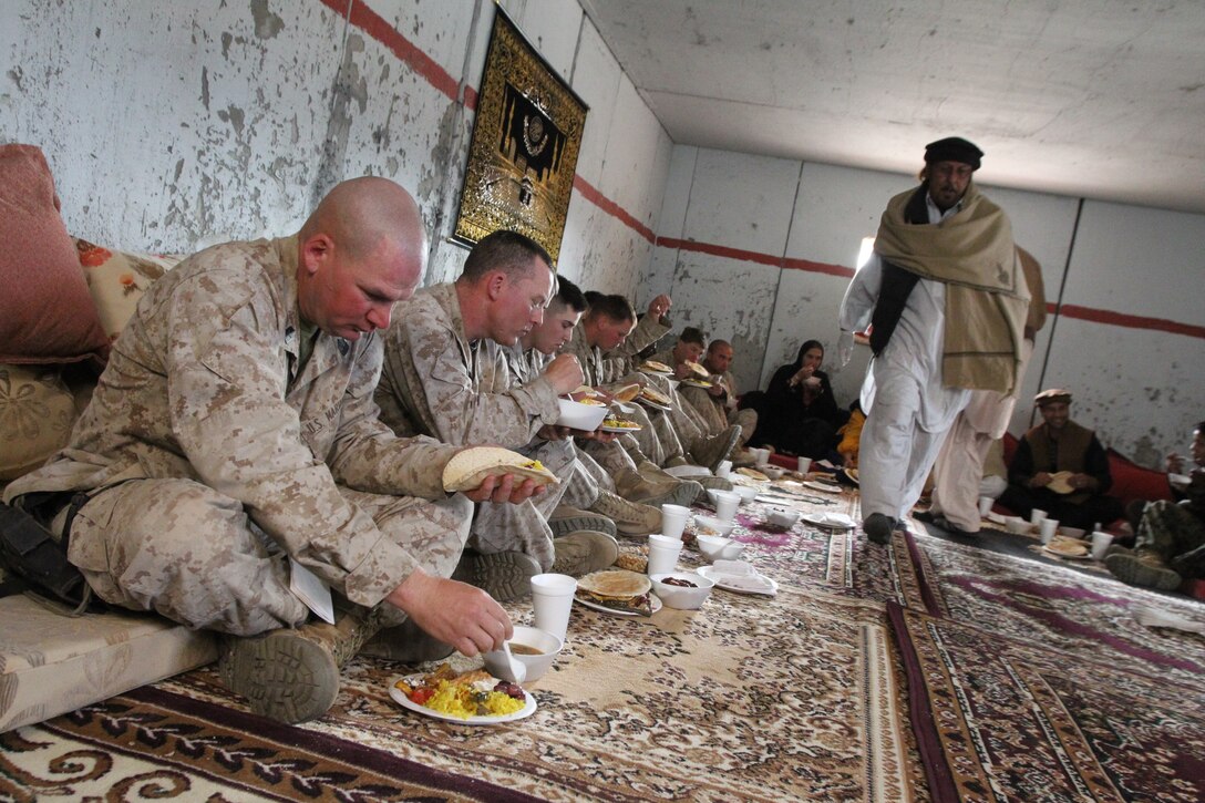 Marines and sailors from 3rd Battalion, 2nd Marine Regiment, out of Camp Lejeune, N.C., eat lunch in an Afghan-style home and eat lunch with the Commandant of the Marine Corps Gen. James Amos and Sergeant Major of the Marine Corps Sgt. Maj. Carlton Kent at Range 210 as part of their Enhanced Mojave Viper training Dec. 6, 2010.