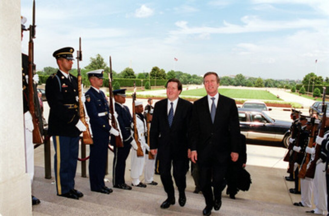 Secretary of Defense William S. Cohen (right) escorts NATO Secretary General Lord George Robertson (left) through an honor cordon and into the Pentagon on June 22, 2000. 