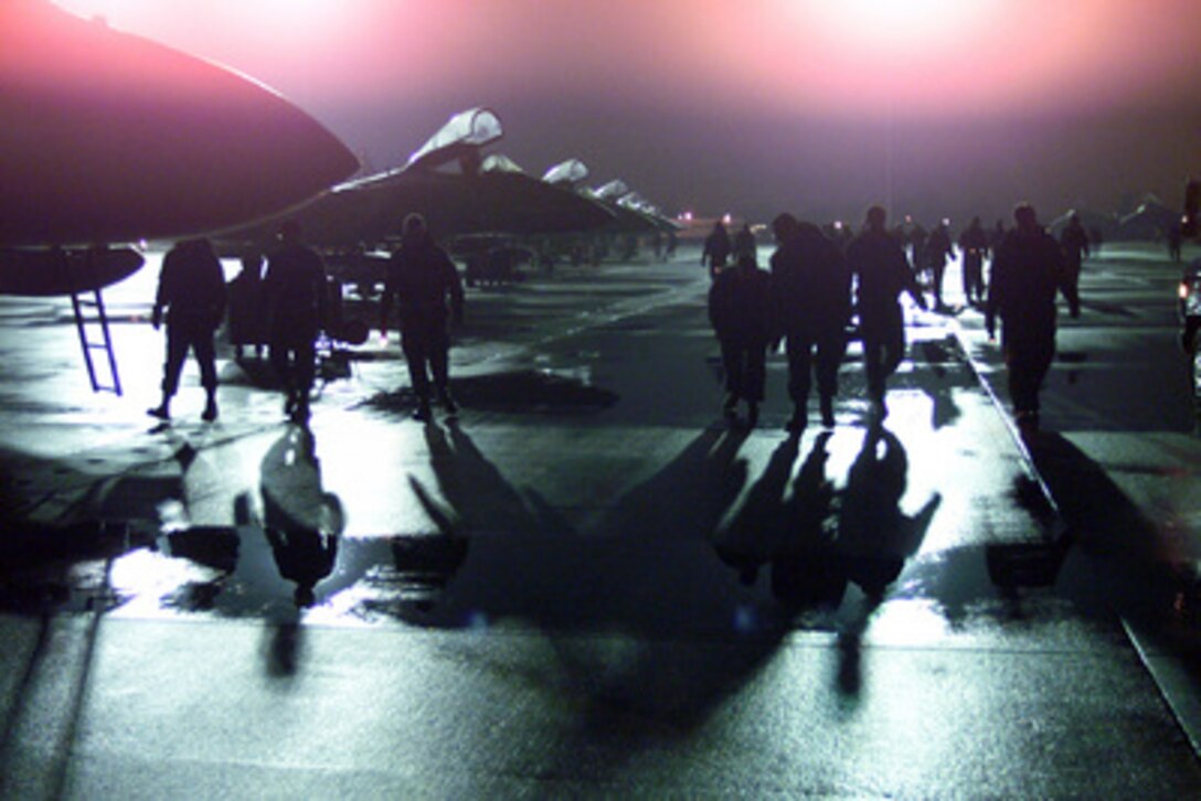 Maintenance crews from the 94th Fighter Squadron, Langley Air Force Base, Va., perform an early morning foreign object damage walk down under the ramp lights on Feb. 14, 2000. The crews are looking for loose items on the ramp that could be sucked into the fighters' jet engines and damage them. The First Fighter Wing is sending nine F-15 Eagles from the 27th Fighter Squadron to Turkey in support of Operation Northern Watch. Northern Watch is the coalition enforcement of the no-fly-zone over Northern Iraq. 