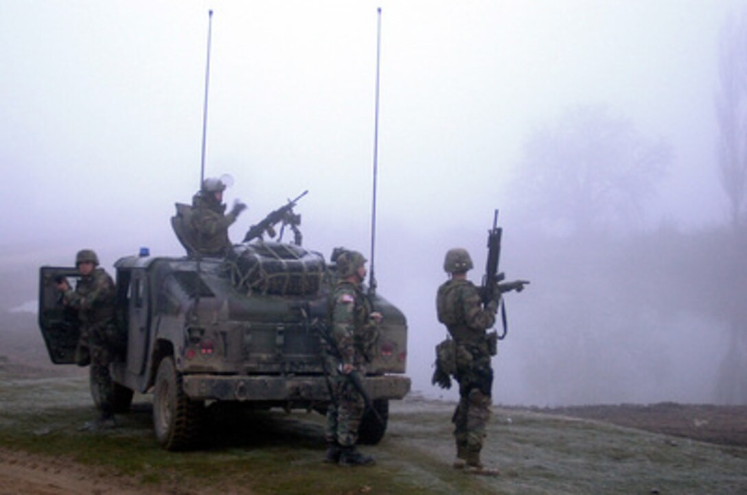 Soldiers from the 65th Military Police Company secured the road out Stublina as units from the 82nd Engineer Battalion began their search in the early morning fog. KFOR soldiers carried out a carefully planned and orchestrated operation on Wednesday, March 15, 2000, to search and confiscate illegal weapons at five separate locations near the Serbian border. A total of 22 crates of ammunition, hand grenades, mines, rifles, other explosives, and chemical protective masks were found. KFOR is the NATO-led, international military force in Kosovo on the peacekeeping mission known as Operation Joint Guardian. 
