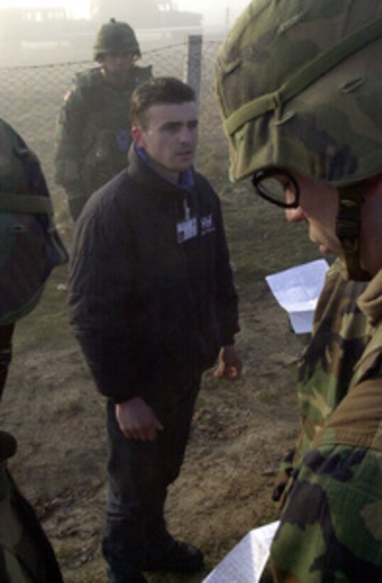 Soldiers questioned a man leaving the village of Stublina. He was found to be carrying documents linking him to a local insurgency group. KFOR soldiers carried out a carefully planned and orchestrated operation on Wednesday, March 15, 2000, to search and confiscate illegal weapons at five separate locations near the Serbian border. A total of 22 crates of ammunition, hand grenades, mines, rifles, other explosives, and chemical protective masks were found. KFOR is the NATO-led, international military force in Kosovo on the peacekeeping mission known as Operation Joint Guardian. 
