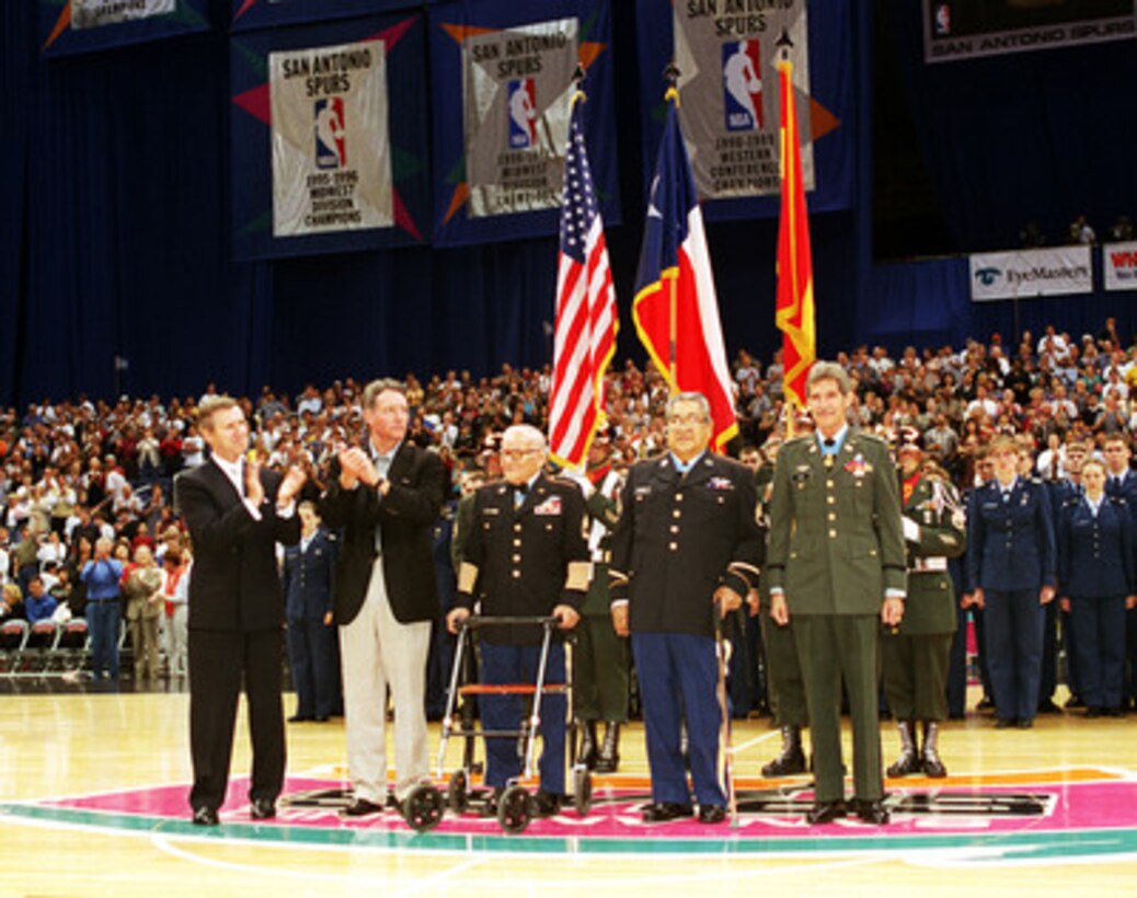 Secretary of Defense William S. Cohen (left) joins San Antonio Spurs' Chairman Peter Holt (2nd from left) in honoring Medal of Honor recipients Jose M. Lopez, Lucien Adams, and Richard Rocco during half-time of the March 2, 2000, game against the Minnesota Timberwolves in San Antonio, Texas. 
