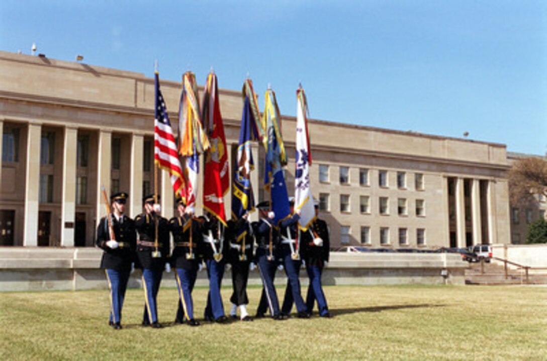 The Joint Service Color Guard marches onto the Pentagon River Parade Field during an armed forces welcoming ceremony on March 7, 2000. 