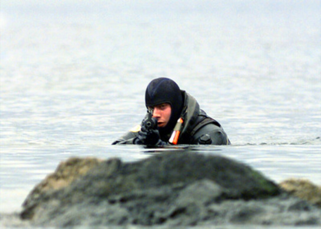 U.S. Marine Cpl. Mark Skolnick scans the shore line as he conducts a beach reconnaissance in Sitka Bay, Alaska, on March 2, 2000, during Exercise Northern Edge 2000. Northern Edge 2000 is Alaska's largest joint military training exercise involving over 10,000 men and women from all five services. Skolnick is attached to Echo Company, 4th Marine Reconnaissance Battalion. 