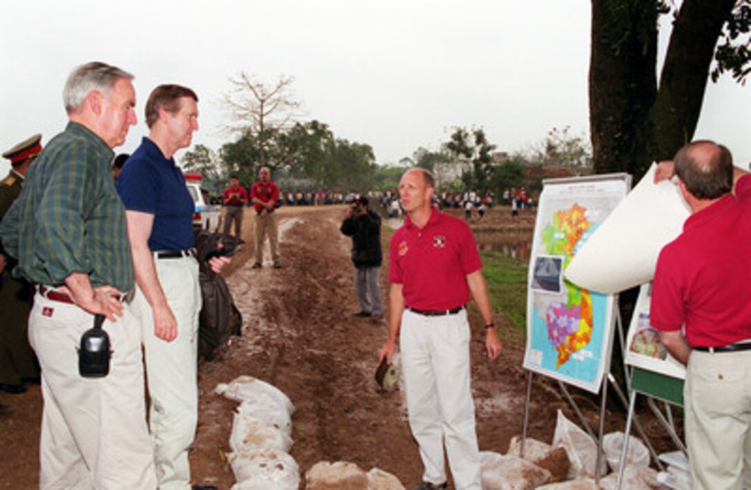 Army Lt. Col. John M. Peppers, commander, Detachment 2, Joint Task Force Full Accounting, briefs U.S. Ambassador to Vietnam Douglas "Pete" Peterson (left) and Secretary of Defense William S. Cohen at a crash excavation site near Hanoi, Vietnam, on March 13, 2000. Cohen traveled to the site to see firsthand the efforts being made and the process involved in the search and recovery of the remains of U.S. servicemen unaccounted for during the Vietnam War. Cohen is the first U.S. defense secretary to visit Vietnam since the end of the Vietnam War in 1975. 