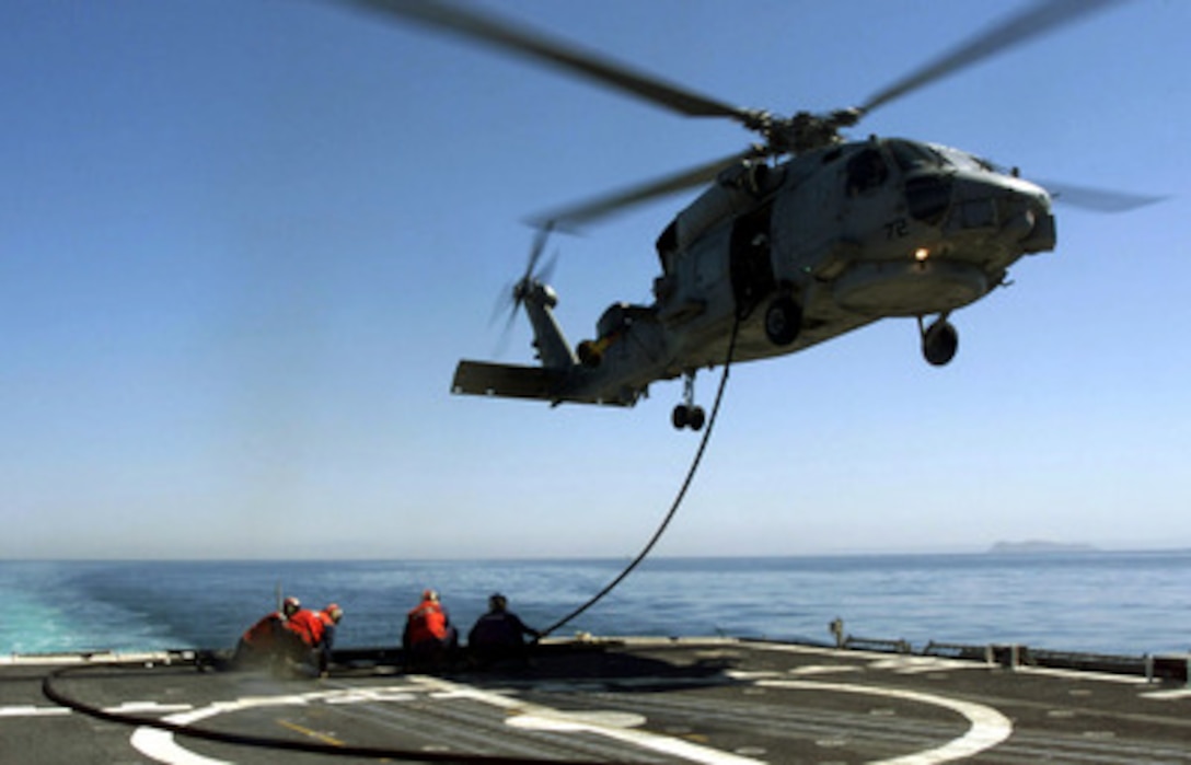 Sailors and aircrew attached to Light Helicopter Anti-Submarine Squadron 47 conduct hot-in-flight refueling of a SH-60B Seahawk helicopter from the deck of the USS Antietam (CG-54) while the ship operates at sea on March 22, 2000. Hot-in-flight refueling is necessary when landing to refuel on a smaller U.S. Navy vessel would be too dangerous for the ship, helicopter and aircrew. USS Antietam is a Ticonderoga class cruiser homeported in San Diego, Calif. The Seahawk is based at Naval Air Station North Island, Calif. 