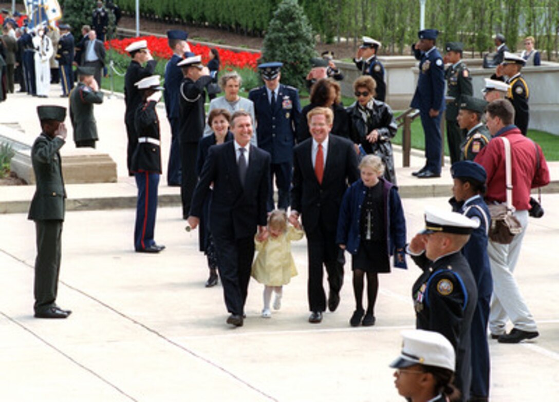 Secretary of Defense William S. Cohen (left) accompanies newly appointed Deputy Secretary of Defense Rudy de Leon (right) and his daughters Libby, (center) and Kerry (far right) as they return to the Pentagon following a ceremony for de Leon on April 19, 2000. Cohen and Vice Chairman of the Joint Chiefs of Staff Gen. Richard B. Myers, U.S. Air Force, hosted the ceremony to officially welcome de Leon and his family to the number two civilian leadership position at the Department of Defense. 