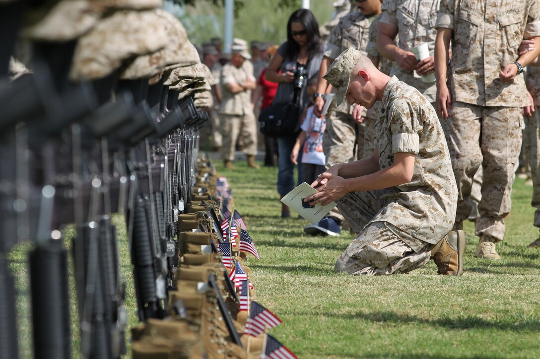 A Marine bows his head in remembrance of a fallen Marine during the Regimental Combat Team 7 memorial ceremony Oct. 15 at Lance Cpl. Torrey L. Gray Field. The units attached to RCT-7 were deployed to Afghanistan from Oct. 24, 2009 to Sept. 28, 2010.::r::::n::
