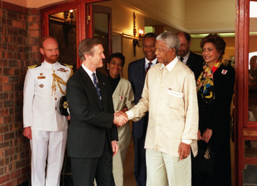 Secretary of Defense William S. Cohen (2nd from left) thanks Nelson Mandela (3rd from right) for meeting with him and members of his delegation at Mandela's home in the village of Qunu, near the town of Umtata, Eastern Cape, South Africa, on Feb. 16, 2000. Also attending the meeting were (L to R in the back row): Capt. Dusty Higgs, South African Navy, military attaché at the Embassy of South Africa in Washington, D. C.; Mrs. Lewis with her husband U.S. Ambassador to South Africa Delano Eugene Lewis, Sr., Deputy Assistant Secretary of Defense for African Affairs Bernd McConnell, and Mrs. Janet Langhart Cohen. 