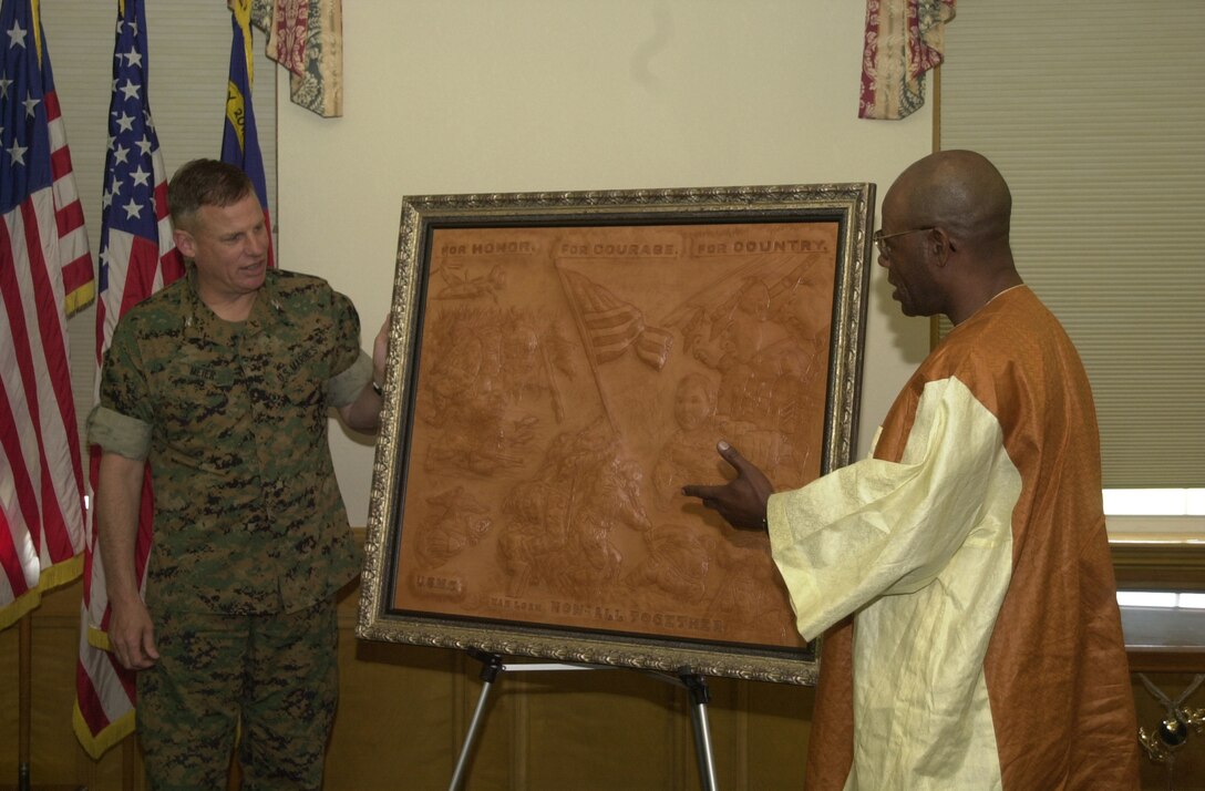 MARINE CORPS BASE CAMP LEJEUNE, N.C. -- Terrence Hill (right), a former 82nd Airborne Division soldier specializing in hand made three-dimensional leather sculptures presented Marine Corps Base Chief of Staff, Col. William Meier and the Marines of Camp Lejeune with his multiple image artwork of Marines and their many achievements, honoring the men and women fighting the Global War on Terrorism.