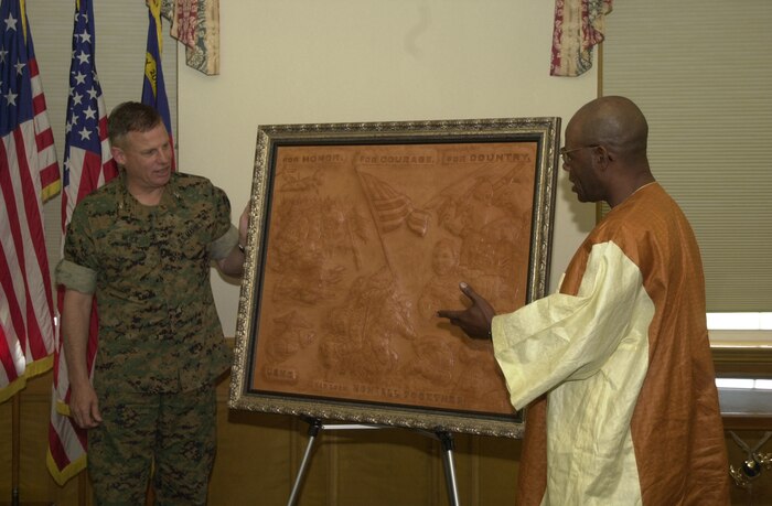 MARINE CORPS BASE CAMP LEJEUNE, N.C. -- Terrence Hill (right), a former 82nd Airborne Division soldier specializing in hand made three-dimensional leather sculptures presented Marine Corps Base Chief of Staff, Col. William Meier and the Marines of Camp Lejeune with his multiple image artwork of Marines and their many achievements, honoring the men and women fighting the Global War on Terrorism.