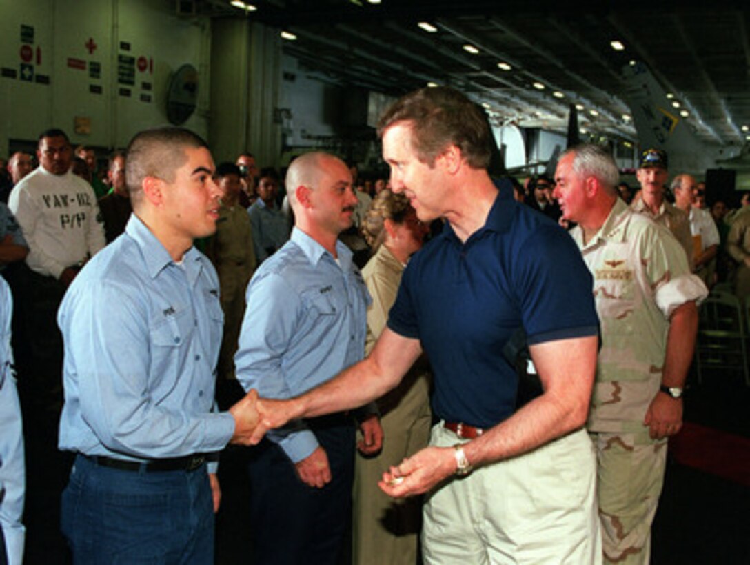 Secretary of Defense William S. Cohen (right) congratulates one of the sailors he re-enlisted aboard the aircraft carrier USS John C. Stennis (CVN-74) as the ship operates in the Persian Gulf on April 7, 2000. Cohen presented each re-enlisting sailor with a commemorative Secretary of Defense coin. Cohen is in the Persian Gulf region to meet with U.S. troops stationed there and defense leaders of the Gulf region. Stennis and its embarked Carrier Air Wing 9 are on station in the Gulf in support of Operation Southern Watch. 