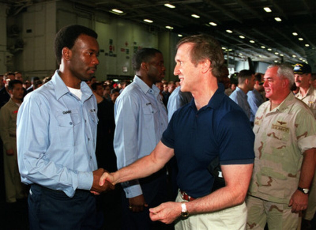 Secretary of Defense William S. Cohen (right) congratulates one of the sailors he re-enlisted aboard the aircraft carrier USS John C. Stennis (CVN-74) as the ship operates in the Persian Gulf on April 7, 2000. Cohen presented each re-enlisting sailor with a commemorative Secretary of Defense coin. Cohen is in the Persian Gulf region to meet with U.S. troops stationed there and defense leaders of the Gulf region. Stennis and its embarked Carrier Air Wing 9 are on station in the Gulf in support of Operation Southern Watch. 