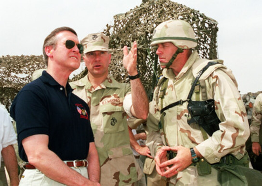 Secretary of Defense William S. Cohen (left) is briefed by Marine Col. Maston Robeson (center) and Col. Richard Zilmer (right) as he observes a live-fire training exercise conducted by Marines of the 15th Marine Expeditionary Unit at the Udairi Training Range in northern Kuwait on April 8, 2000. Cohen is in the Persian Gulf region to meet with U.S. troops stationed there and defense leaders of the Gulf region. Robeson is Cohen's junior military assistant. Zilmer is the commander of the 15th Marine Expeditionary Unit. 