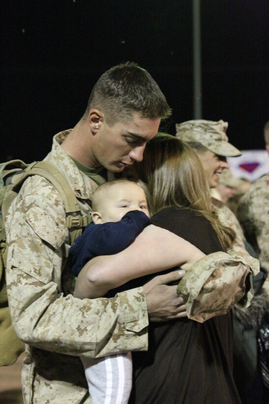 A Marine holds his family at the 3rd Battalion 7th Marines homecoming early Oct. 23, 2010, at Del Valle softball fields. Company I, Combat Replacements and the Command Element came home Sunday, and the last company in the battalion, Weapons Company, came home Monday. (U.S. Marine Corps photo by Lance Cpl. Sarah Anderson)