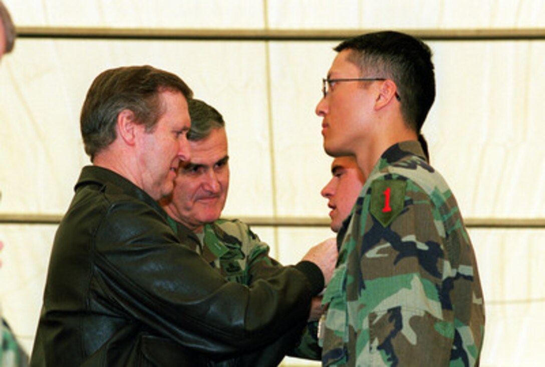 Secretary of Defense William S. Cohen (left) and Chairman of the Joint Chiefs of Staff Gen. Henry H. Shelton (2nd from left) pin rank insignia on newly promoted soldiers of Task Force Falcon during a troop visit to Camp Bondsteel, Kosovo, on May 1, 2000. 