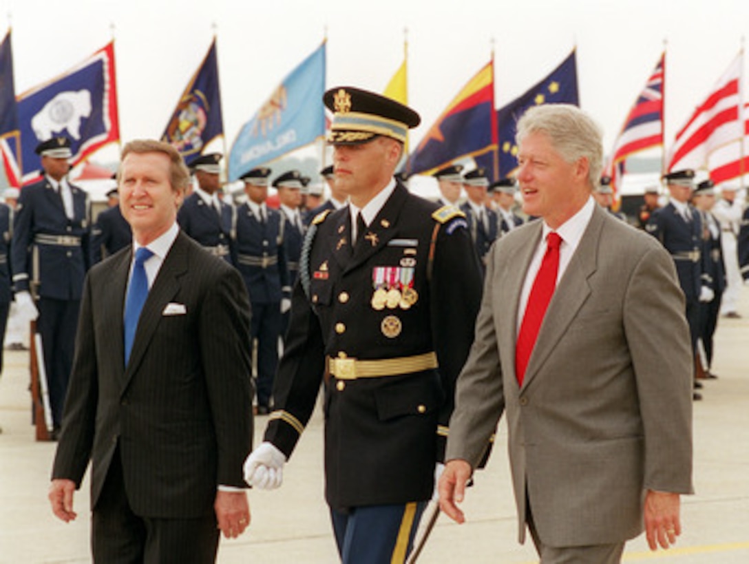 President Bill Clinton (right) and Secretary of Defense William S. Cohen (left) are escorted by Commander of Troops Col. Thomas M. Jordan (center), U.S. Army, as they return to the reviewing stand after inspecting the joint service honor guard at Andrews Air Force Base, Md., on May 19, 2000. Clinton and Cohen are taking part in the opening ceremonies of the annual joint services open house and air show at Andrews, which this year commemorates the 50th anniversary of Armed Forces Day. 