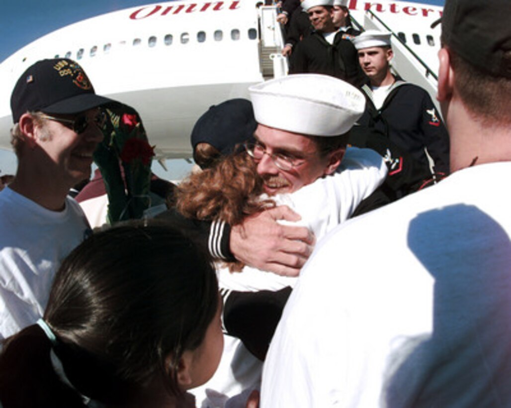 A sailor from the USS Cole (DDG 67) is greeted by friends and family members as the crew returns to their home port at Naval Station Norfolk, Va., on Nov. 3, 2000. The Arleigh Burke class destroyer was the target of a suspected terrorist attack in the port of Aden, Yemen, on Oct. 12, 2000, during a scheduled refueling. The attack killed 17 crew members and injured 39 others. The USS Cole is being transported by the Norwegian heavy transport ship M/V Blue Marlin back to the United States for repair. 