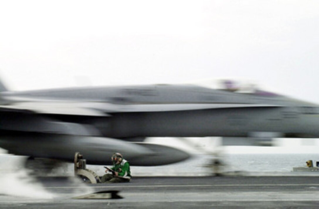 It's another day at work for this sailor as over 20 tons of F/A-18 Hornet roars over his head and off the steam catapult of the USS Abraham Lincoln (CVN 72) while the ship operates in the Persian Gulf on Nov. 3, 2000. This Navy aviation boatswain's mate is monitoring steam pressure used to launch aircraft from the flight deck of the aircraft carrier. Lincoln, and its embarked Carrier Air Wing 14, are on station in the Persian Gulf in support of Operation Southern Watch, which is the U.S. and coalition enforcement of the no-fly-zone over Southern Iraq. 