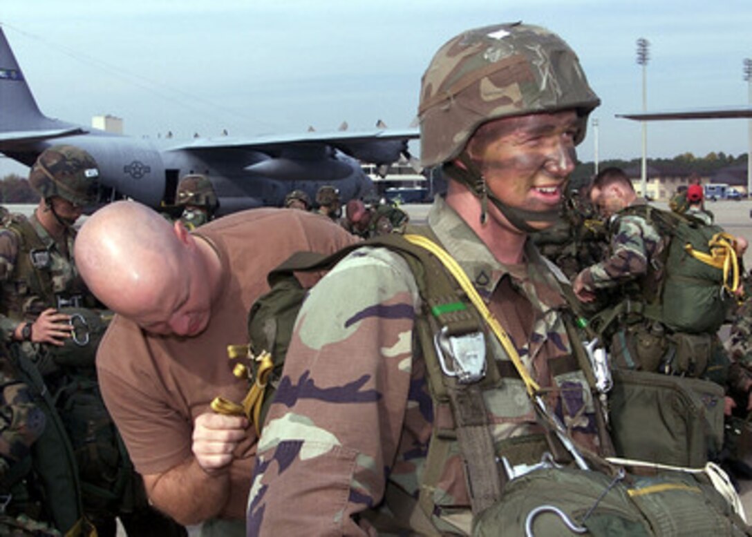 U.S. Army Pfc. David Woodfuff (right) gets a final safety check of his parachute rigging from Sgt. Sterling Hess at Pope Air Force Base, N.C., on Nov. 7, 2000. Woodfuff and other soldiers of the 82nd Airborne are taking part in an aerial assault exercise called Large Package Week. The quarterly training exercise sharpens the airdrop capability of aircrews from the Air Mobility Command and the 82nd Airborne. The parachutists will jump over the Sicily Drop Zone at Fort Bragg, N.C. 
