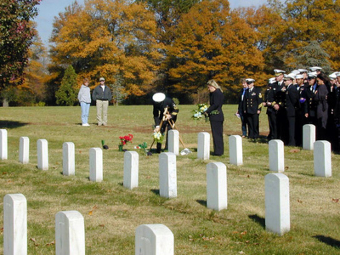 Sailors from the USS Cole (DDG 67) pay their respects to recently buried Cole crew members at Arlington National Cemetery on Nov. 11, 2000. Cole sailors were invited to take part in Veterans Day receptions and ceremonies at the White House and Arlington Cemetery. The Arleigh Burke class destroyer was the target of a suspected terrorist attack in the port of Aden, Yemen, on Oct. 12, 2000, during a scheduled refueling. The attack killed 17 crew members and injured 39 others. 