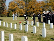 Sailors from the USS Cole (DDG 67) pay their respects to recently buried Cole crew members at Arlington National Cemetery on Nov. 11, 2000. Cole sailors were invited to take part in Veterans Day receptions and ceremonies at the White House and Arlington Cemetery. The Arleigh Burke class destroyer was the target of a suspected terrorist attack in the port of Aden, Yemen, on Oct. 12, 2000, during a scheduled refueling. The attack killed 17 crew members and injured 39 others. 