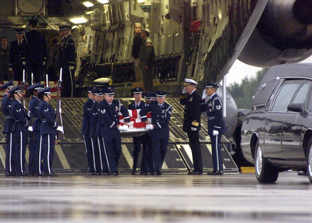 A U.S. Air Force honor guard carries the remains of a sailor killed in the suspected terrorist attack on the USS Cole (DDG 67) from a C-17 Globemaster III at Ramstein Air Base, Germany, on Oct. 13, 2000. The attack on the Arleigh Burke class destroyer took place in the Yemen port city of Aden on Oct. 12, 2000. 