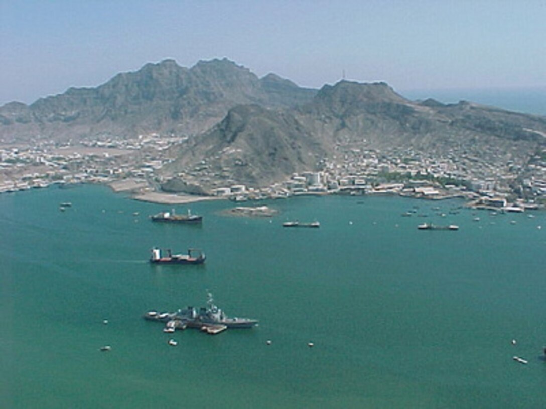 The U.S. Navy guided missile destroyer USS Cole (DDG 67) (foreground) remains moored to a refueling platform in the industrial harbor in Aden, Yemen, on Oct. 15, 2000. The Arleigh Burke class destroyer was the target of a suspected terrorist attack which took place in the port of Aden on Oct. 12, 2000, during a scheduled refueling. Nine sailors were killed and eight have been listed as missing. 