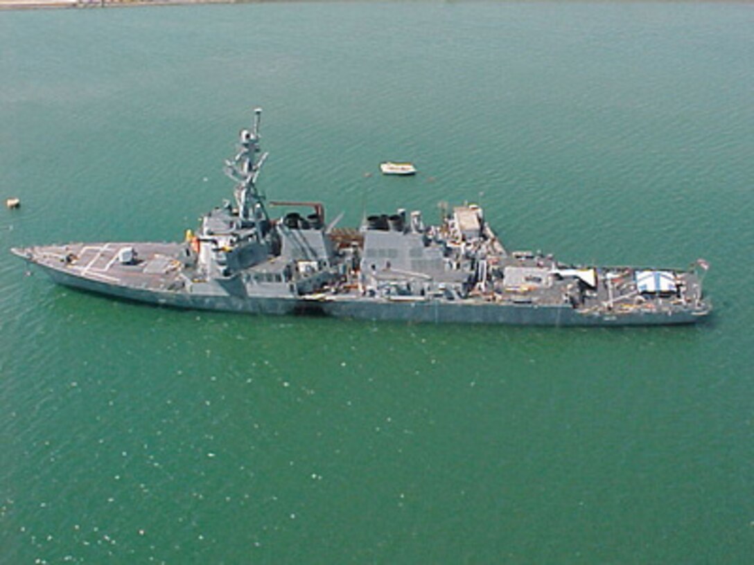 The U.S. Navy guided missile destroyer USS Cole (DDG 67) remains moored to a refueling platform in the industrial harbor in Aden, Yemen, on Oct. 15, 2000. The Arleigh Burke class destroyer was the target of a suspected terrorist attack which took place in the port of Aden on Oct. 12, 2000, during a scheduled refueling. Nine sailors were killed and eight have been listed as missing. 