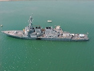 The U.S. Navy guided missile destroyer USS Cole (DDG 67) remains moored to a refueling platform in the industrial harbor in Aden, Yemen, on Oct. 15, 2000. The Arleigh Burke class destroyer was the target of a suspected terrorist attack which took place in the port of Aden on Oct. 12, 2000, during a scheduled refueling. Nine sailors were killed and eight have been listed as missing. 