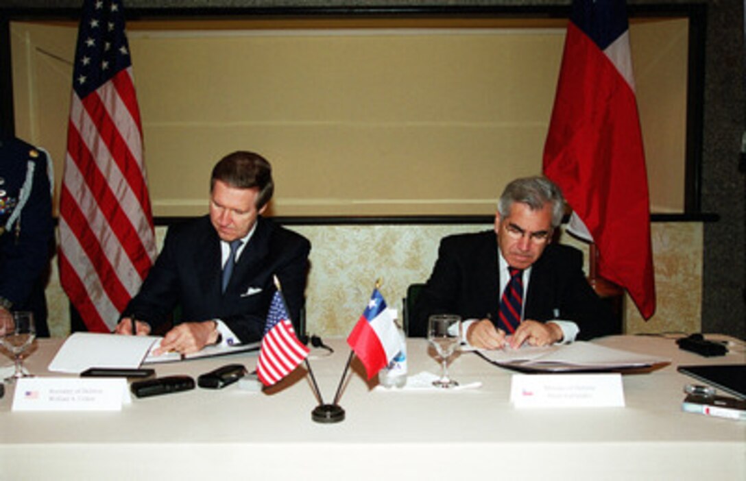 Secretary of Defense William S. Cohen (left) and Chilean Minister of Defense Mario Fernandez Baeza (right) sign a new acquisition and cross-servicing agreement in Manaus, Brazil, on Oct. 17, 2000. The agreement will facilitate the exchange of non-lethal equipment, increase cooperation in the field and reduce the paperwork involved. It also allows the two militaries to exchange goods and services such as refueling at sea, shipyard services, and it permits Chile to help resupply our Navy in distant ports. The defense leaders are in Manaus attending the Defense Ministerial of the Americas IV. 