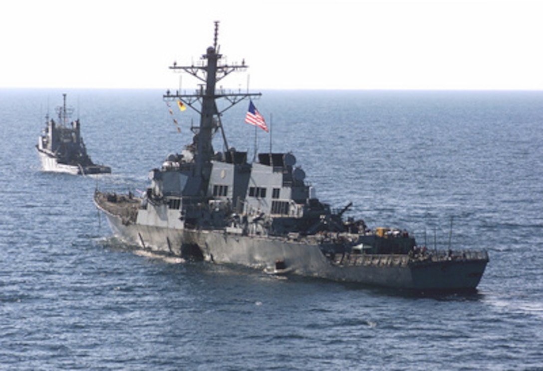 The USS Cole (DDG 67) is towed away from the port city of Aden, Yemen, into open sea by the Military Sealift Command ocean-going tug USNS Catawba (T-ATF 168) on Oct. 29, 2000. Cole will be placed aboard the Norwegian heavy transport ship M/V Blue Marlin and transported back to the United States for repair. The Arleigh Burke class destroyer was the target of a suspected terrorist attack in the port of Aden on Oct. 12, 2000, during a scheduled refueling. The attack killed 17 crew members and injured 39 others. 