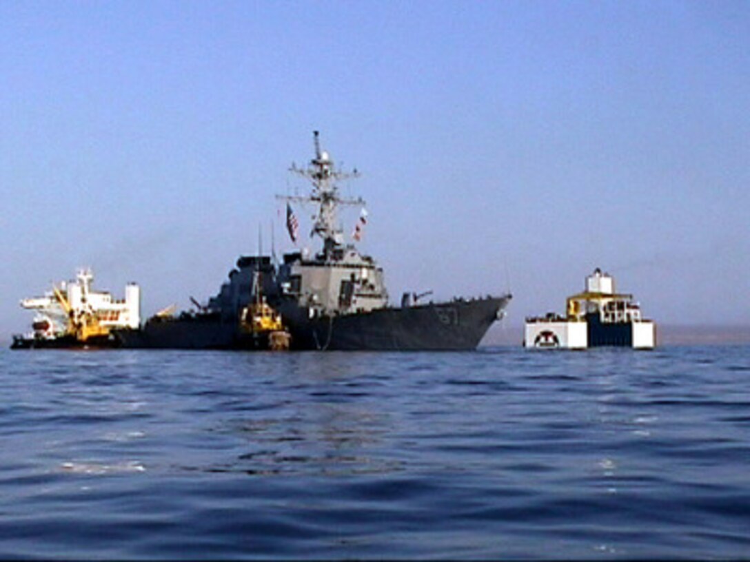 The USS Cole (DDG 67) (left) waits for the Norwegian heavy transport ship M/V Blue Marlin to maneuver under the destroyer off the coast of Aden, Yemen, on Oct. 30, 2000. Cole will be placed aboard the Blue Marlin and transported back to the United States for repair. The Arleigh Burke class destroyer was the target of a suspected terrorist attack in the port of Aden on Oct. 12, 2000, during a scheduled refueling. The attack killed 17 crew members and injured 39 others. 