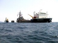 The USS Cole (DDG 67) is slowly lifted from the water by the Norwegian heavy transport ship M/V Blue Marlin off the coast of Aden, Yemen, on Oct. 30, 2000. Cole will be transported aboard the Blue Marlin back to the United States for repair. The Arleigh Burke class destroyer was the target of a suspected terrorist attack in the port of Aden on Oct. 12, 2000, during a scheduled refueling. The attack killed 17 crew members and injured 39 others. 