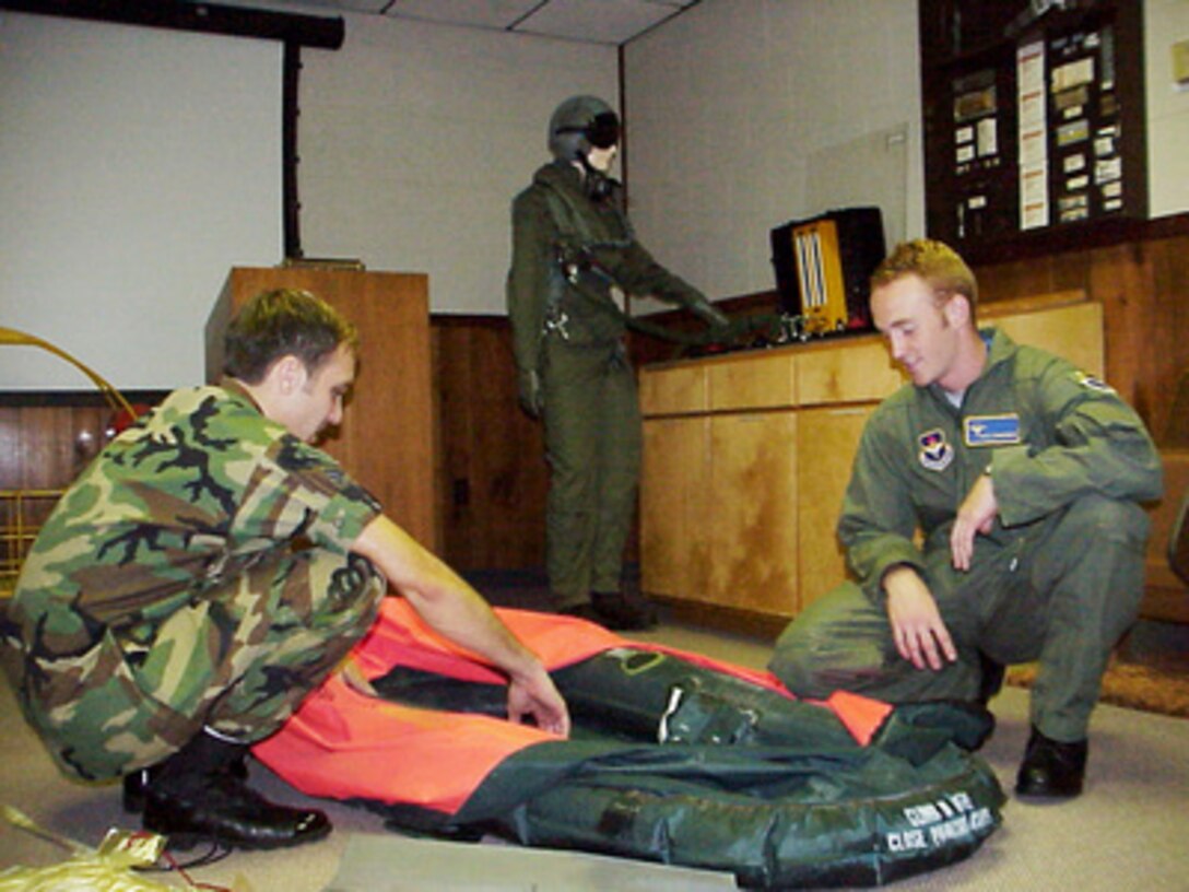 U.S. Air Force Senior Airman Matt P. Kurpaski points out the features of a life raft to Dale Zimmerman during emergency egress training at Tyndall Air Force Base, Fla., prior to an orientation flight in an F-15 Eagle on Aug. 24, 2000. Zimmerman is the Air Force winner of the Yahoo! Fantasy Careers in Today's Military Contest and is spending a two-day adventure as an honorary F-15 pilot. Kurpaski is a life support journeyman attached to the 95th Fighter Squadron at Tyndall. Zimmerman, 22, from Junction City, Ore., is a customer service representative for United Airlines. 