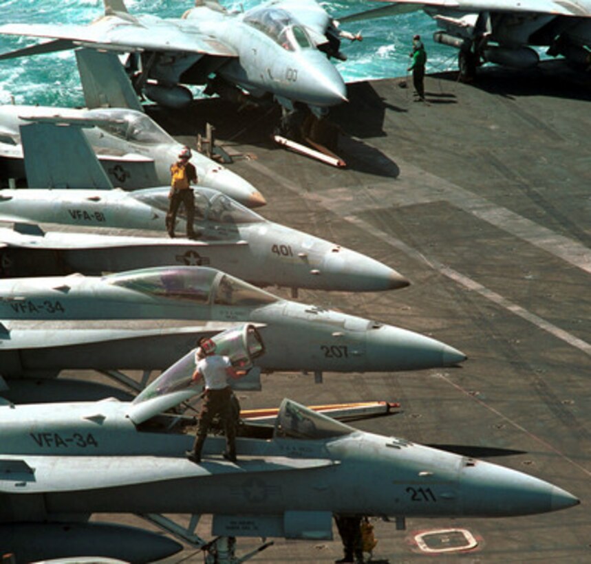 U.S. Navy plane captains clean the canopies of F/A-18 Hornets on the flight deck of the USS George Washington (CVN 73) in preparation for flight operations in the Persian Gulf on Sept. 2, 2000. Washington and its embarked Carrier Air Wing 17 are on station in the Persian Gulf in support of Operation Southern Watch, which is the U.S. and coalition enforcement of the no-fly-zone over Southern Iraq. The Hornets are attached to Strike Fighter Squadrons 34 and 81 of Oceana Naval Air Station, Va. Department of Defense photo. 
