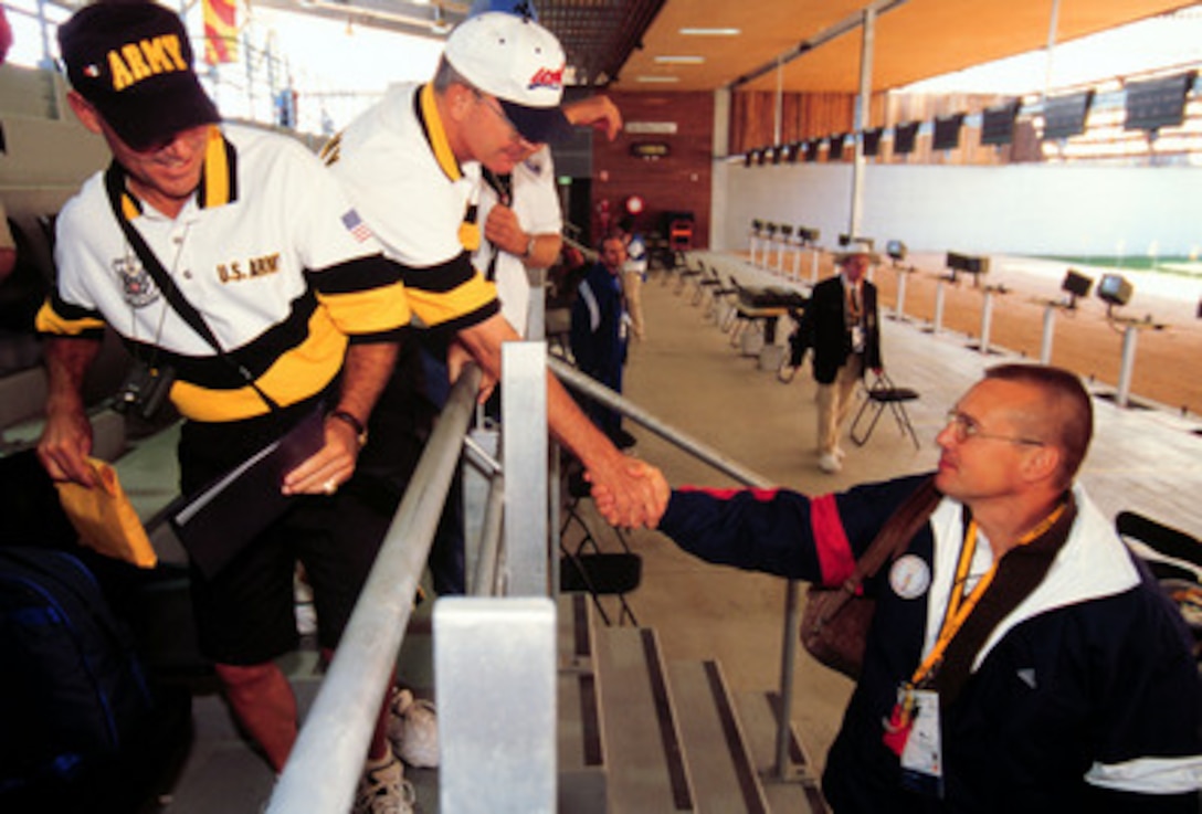 Army Sgt. 1st Class Daryl L. Szarenski (right) shakes hands with Col. Arch V. Arnold III (center) after competing in the 2000 Olympic Games in Sydney, Australia, on Sept. 19, 2000. Szarenski scored a 550 but failed to advance into the finals. Fifteen U.S. military athletes are competing in the 2000 Olympic games as members of the U.S. Olympic team. In addition to the 15 competing athletes there are eight alternates and five coaches representing each of the four services in various venues. Szarenski and Arnold are attached to the U.S. Army Marksmanship Unit, Fort Benning, Ga. 