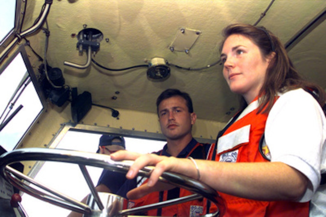 Stephanie Kelley takes the helm of a Coast Guard 41-foot utility boat under the watchful eye of Petty Officer 2nd Class Bill Pierce, U.S. Coast Guard, near Galveston, Texas on Sept. 13, 2000. Kelley, 22, from Stow, Mass., is the Coast Guard winner of the Yahoo! Fantasy Careers in Today's Military Contest. The Duke University graduate is experiencing a day in the life of a boat crew as part of the contest. 