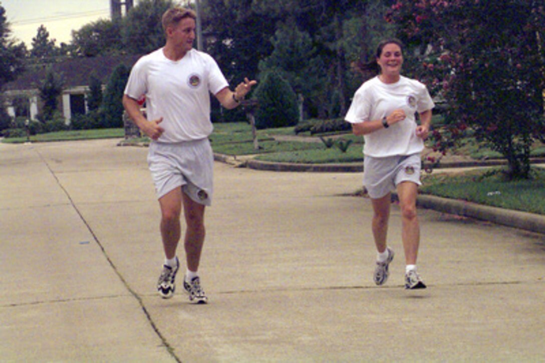 Petty Officer 3rd Class Mark Pipkin (left) and Stephanie Kelley run a mile and one-half as part of rescue swimmer training with the Coast Guard Air Station Houston, Texas, rescue swimmers on Sept. 14, 2000. Kelley, 22, from Stow, Mass., is the Coast Guard winner of the Yahoo! Fantasy Careers in Today's Military Contest. The Duke University graduate is experiencing a day in the life of a rescue swimmer as part of the contest. 