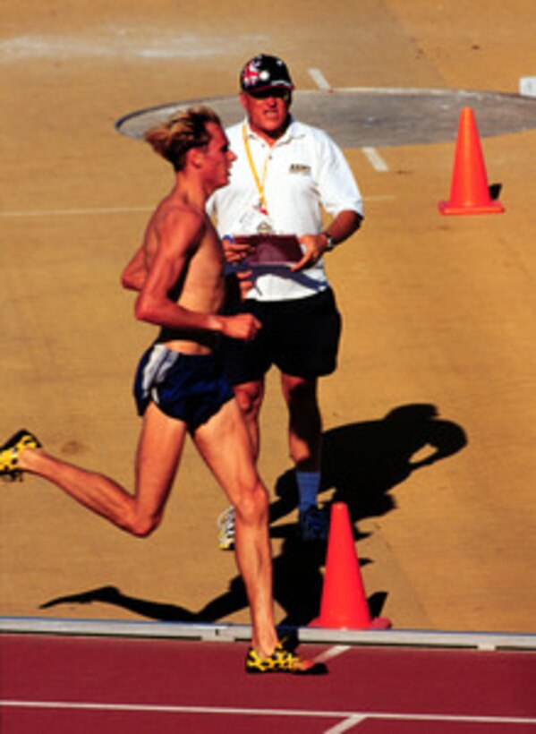 Coach Jerry Quiller works with Nick Rogers as he prepares for the 5,000 meter run at the 2000 Olympic Games in Sydney, Australia, on Sept. 20, 2000. Quiller, who is the Track and Field coach at West Point, is the U.S. Assistant Men's Track and Field Coach for distance runners at the 2000 games. Fifteen U.S. military athletes are competing in the 2000 Olympic games as members of the U.S. Olympic team. In addition to the 15 competing athletes there are eight alternates and five coaches representing each of the four services in various venues. 